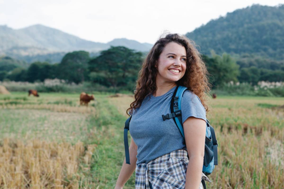 A female traveller hiking in a field